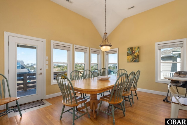 dining room featuring a healthy amount of sunlight, visible vents, and light wood-type flooring