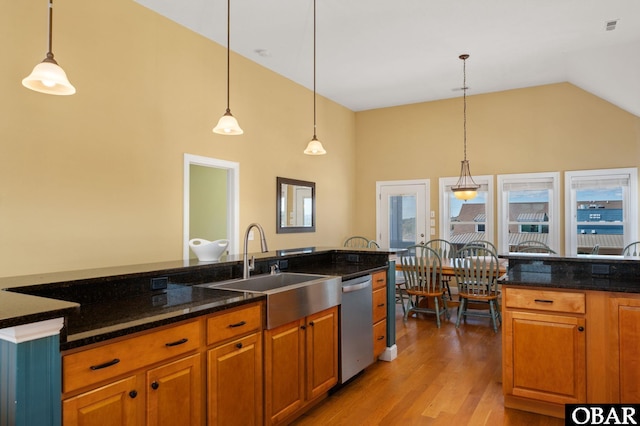 kitchen with high vaulted ceiling, a sink, brown cabinetry, light wood-style floors, and dishwasher