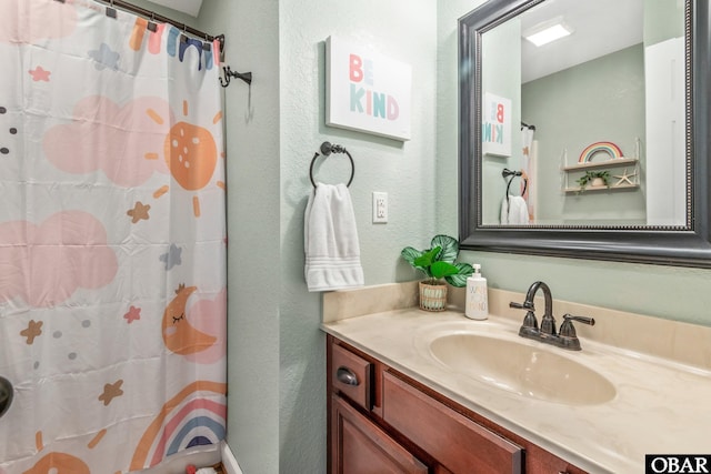 100 Amherst Dr Unit 3, Kill Devil Hills, NC 27948 - bathroom featuring a textured wall, vanity, and curtained shower