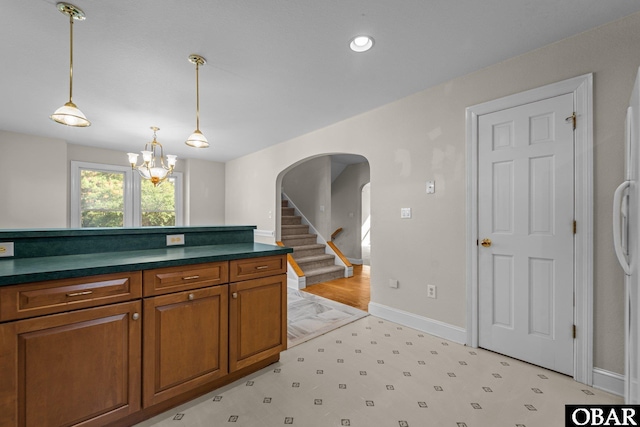 604 W First St Lot 321, Kill Devil Hills, NC 27948 - kitchen with light floors, arched walkways, dark countertops, brown cabinets, and a chandelier