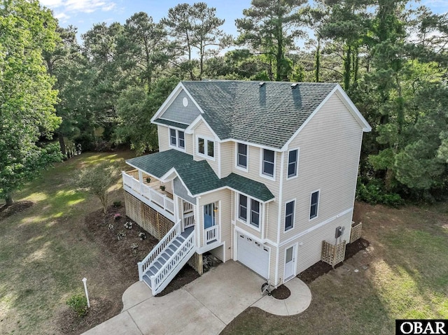 604 W First St Lot 321, Kill Devil Hills, NC 27948 - view of front of home with roof with shingles, stairway, concrete driveway, view of wooded area, and an attached garage