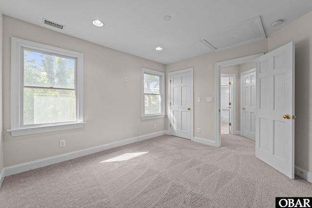 604 W First St Lot 321, Kill Devil Hills, NC 27948 - unfurnished bedroom with multiple windows, attic access, light carpet, baseboards, and recessed lighting