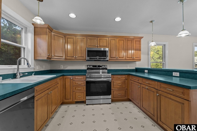 604 W First St Lot 321, Kill Devil Hills, NC 27948 - kitchen with appliances with stainless steel finishes, a sink, brown cabinetry, dark countertops, and a peninsula