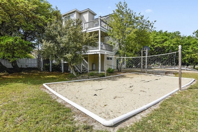 view of property's community featuring volleyball court, a yard, and fence