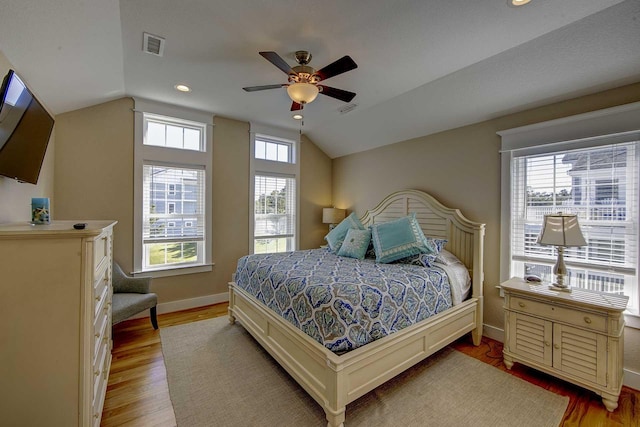 bedroom with visible vents, vaulted ceiling, baseboards, and wood finished floors