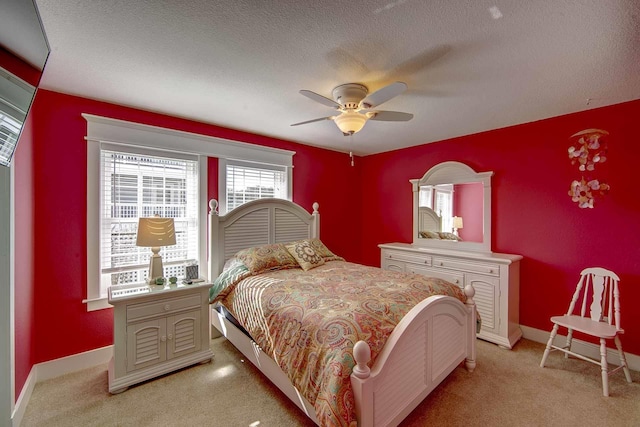 bedroom featuring light colored carpet, ceiling fan, a textured ceiling, and baseboards