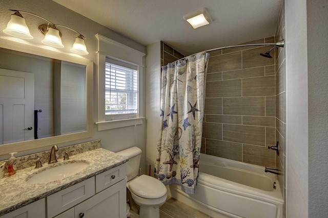 bathroom with toilet, a textured wall, vanity, and shower / bathtub combination with curtain