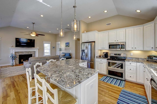 kitchen featuring appliances with stainless steel finishes, a center island, and open floor plan