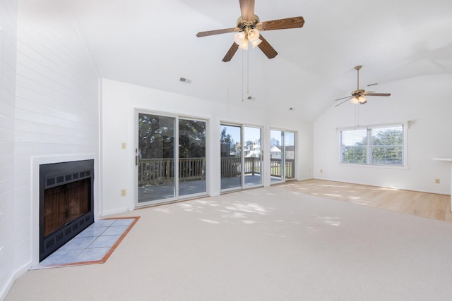 unfurnished living room with ceiling fan, high vaulted ceiling, light colored carpet, a fireplace, and visible vents