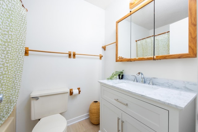 bathroom featuring baseboards, vanity, toilet, and wood finished floors