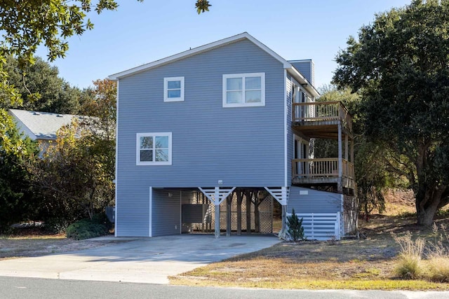 view of front of home featuring a carport, concrete driveway, and a balcony