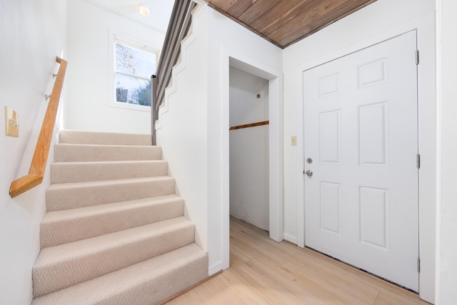 stairway with wooden ceiling and wood finished floors