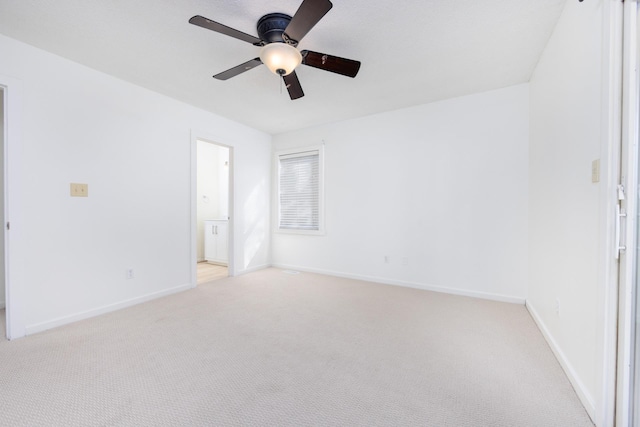 spare room featuring baseboards, ceiling fan, and light colored carpet