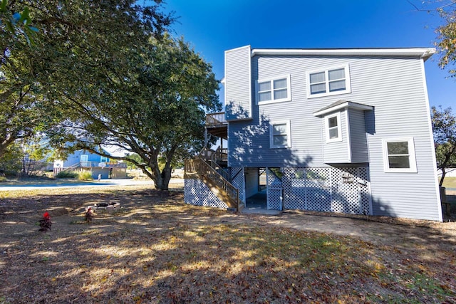 back of house with a carport, a deck, and stairs