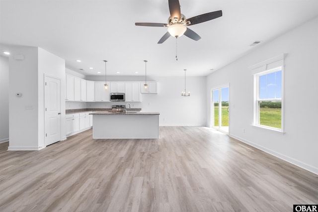 104 Yadkin Dr Lot # 77, South Mills, NC 27973 - kitchen with stainless steel microwave, a ceiling fan, open floor plan, an island with sink, and light wood-type flooring