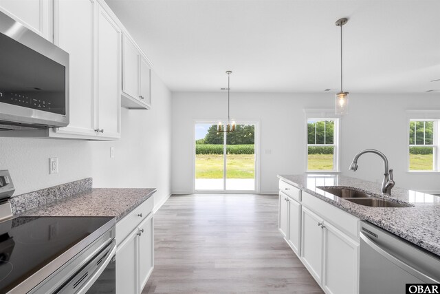 104 Yadkin Dr Lot # 77, South Mills, NC 27973 - kitchen with stainless steel appliances, light wood-style flooring, white cabinetry, and light stone counters