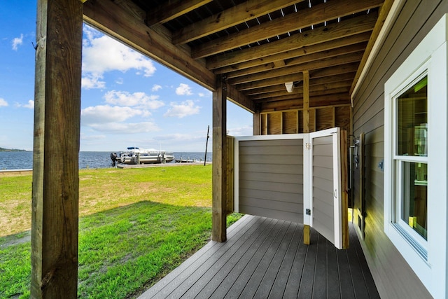 deck with a water view and a yard