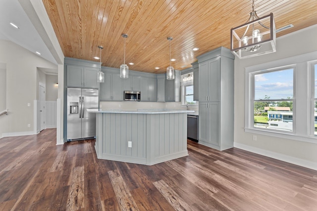 kitchen featuring a kitchen island, hanging light fixtures, gray cabinets, stainless steel appliances, and light countertops