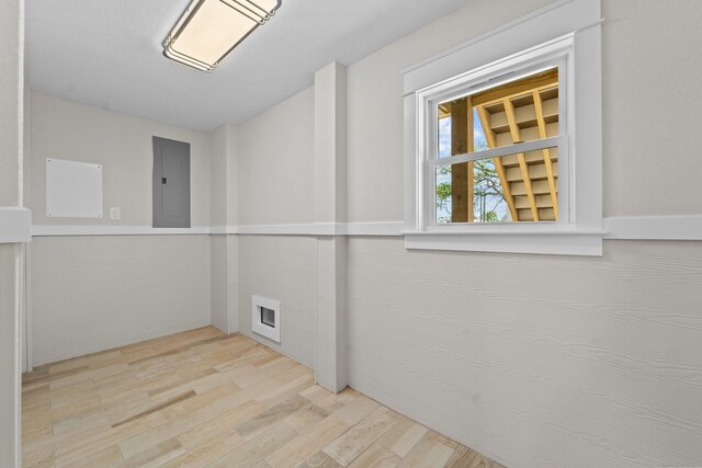 unfurnished room with light wood-type flooring and electric panel