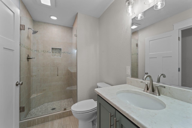 full bath featuring a shower stall, vanity, and toilet