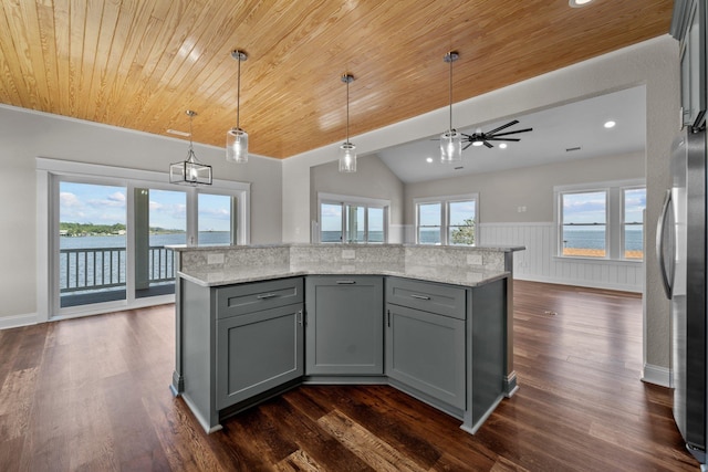 kitchen with freestanding refrigerator, a water view, hanging light fixtures, and gray cabinetry