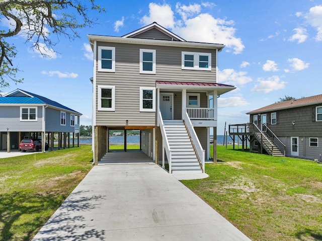 coastal home with stairway, a front lawn, and a carport