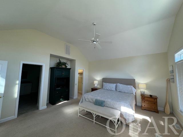 bedroom with lofted ceiling, visible vents, light carpet, and baseboards