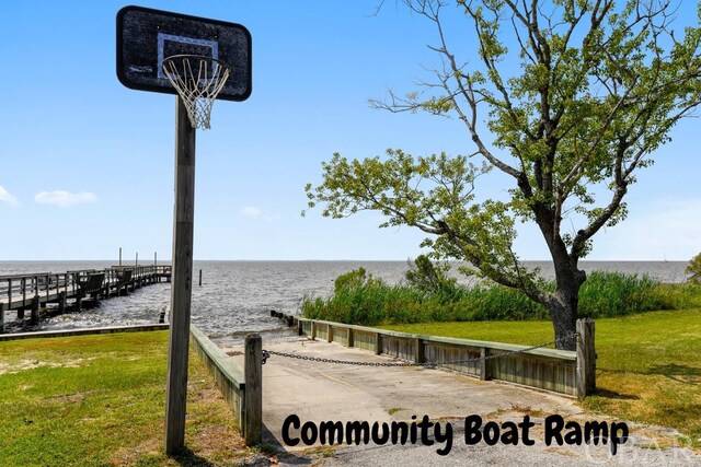 surrounding community with a water view and a yard