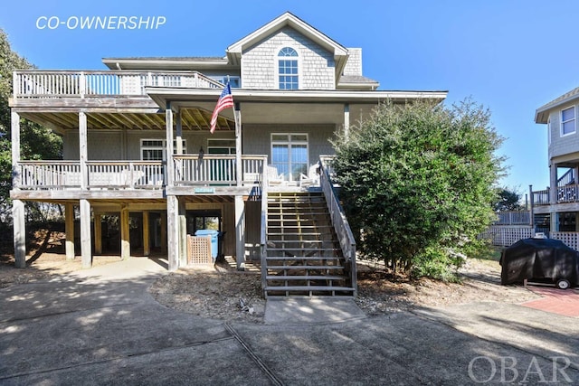 beach home featuring driveway, stairs, a porch, and a carport