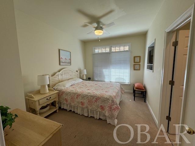 bedroom featuring light carpet, a ceiling fan, and baseboards