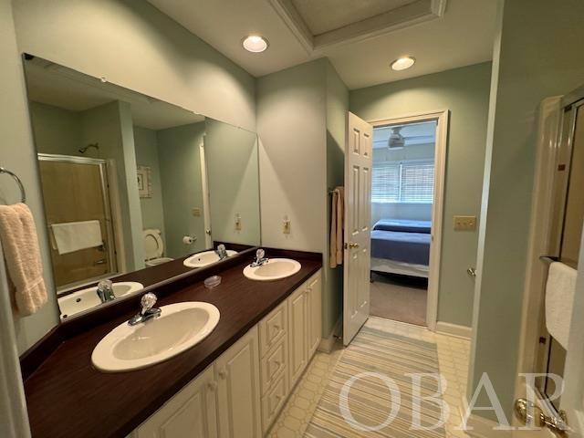 ensuite bathroom with a sink, ensuite bath, and double vanity