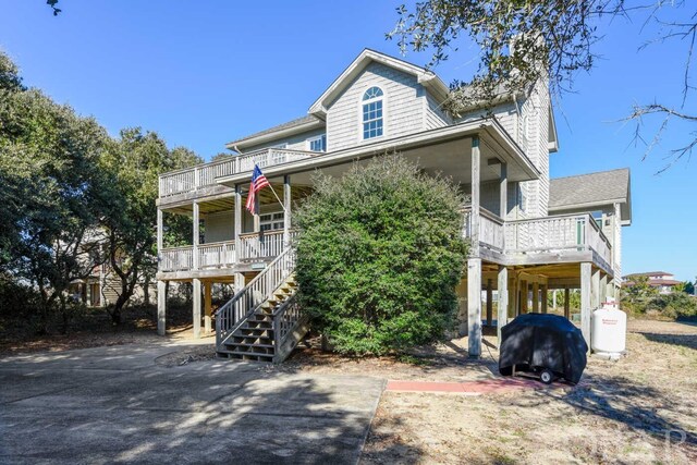 coastal home featuring a balcony, stairway, and a carport