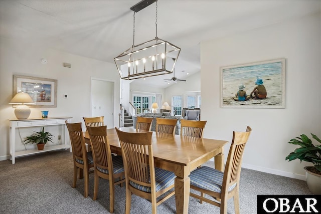 dining area featuring dark colored carpet, ceiling fan, vaulted ceiling, baseboards, and stairs