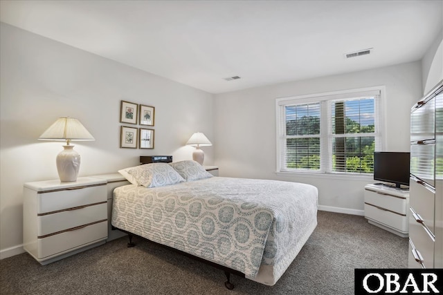 bedroom with visible vents, dark carpet, and baseboards