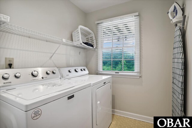 washroom featuring laundry area, baseboards, and washer and dryer