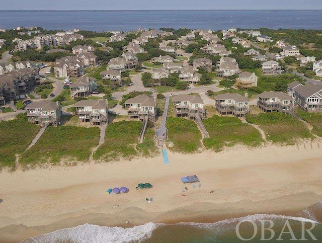 bird's eye view featuring a water view and a beach view