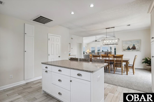 114 Mainsail Ct Lot # 7, Duck, NC 27949 - kitchen with wood tiled floors, a center island, white cabinetry, stone counters, and recessed lighting