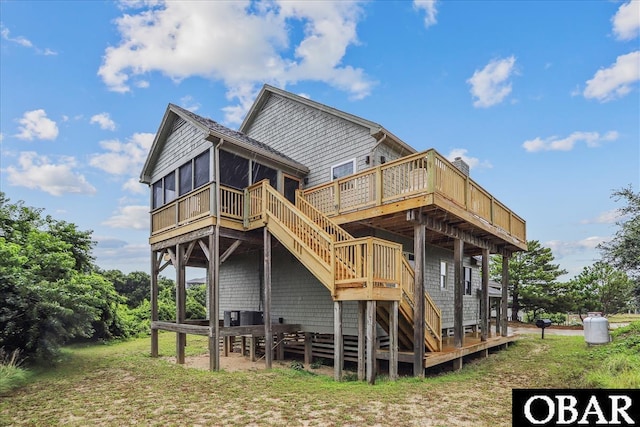 rear view of house with a sunroom, stairs, and a deck