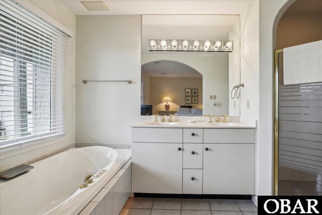 full bath with a garden tub, double vanity, a sink, and tile patterned floors