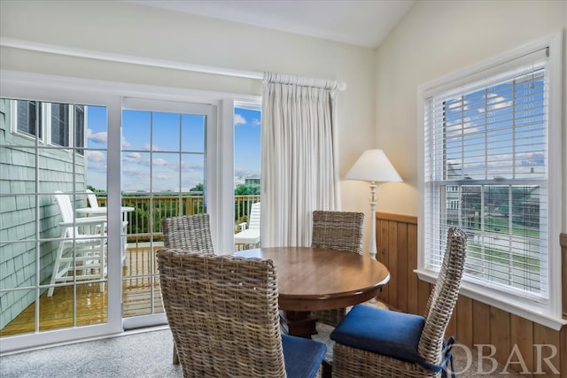 dining area featuring lofted ceiling, wainscoting, and a wealth of natural light