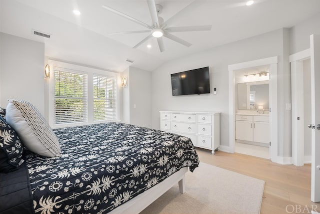 bedroom featuring light wood finished floors, baseboards, connected bathroom, lofted ceiling, and recessed lighting