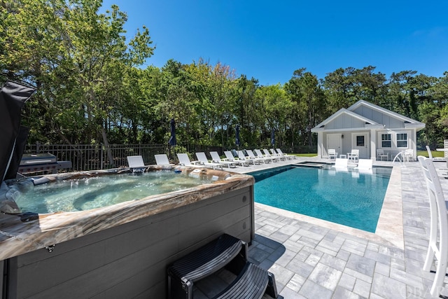 view of swimming pool featuring a patio, a storage structure, an outdoor structure, fence, and an outdoor hot tub