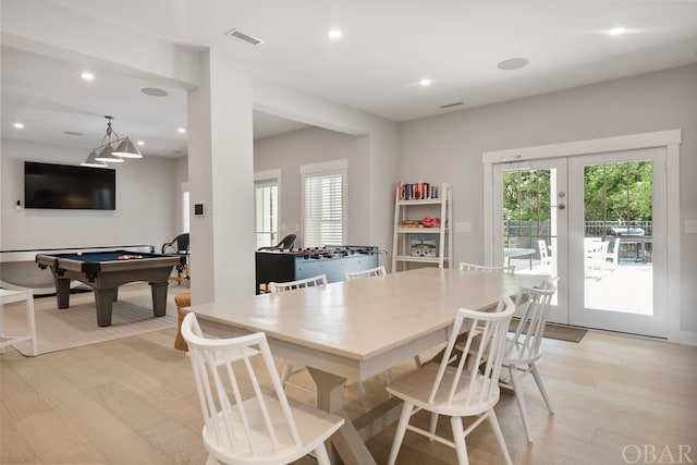 dining room featuring light wood-type flooring, plenty of natural light, visible vents, and french doors