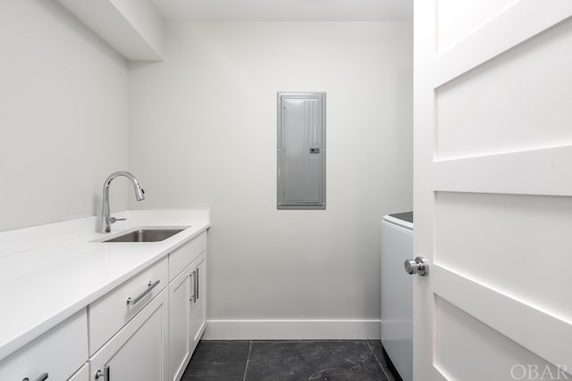 laundry area featuring electric panel, a sink, and baseboards