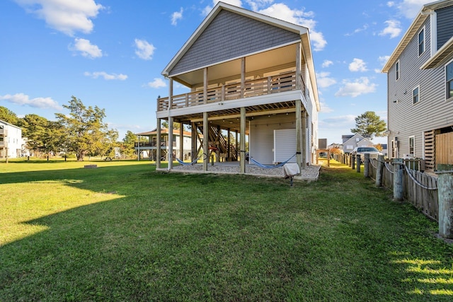 back of house featuring a deck, a patio, a lawn, and fence