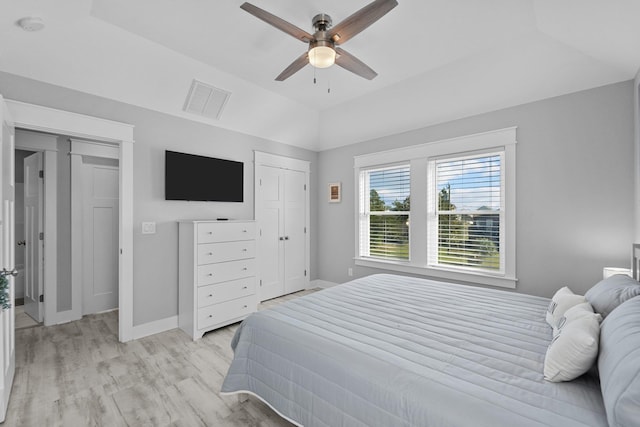 bedroom with baseboards, visible vents, a ceiling fan, lofted ceiling, and light wood-type flooring