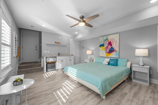 bedroom with light wood-style flooring, visible vents, a sink, and recessed lighting