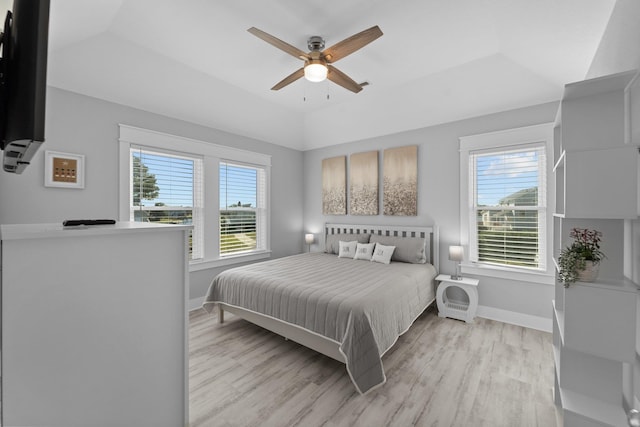 bedroom featuring light wood-type flooring, multiple windows, and baseboards