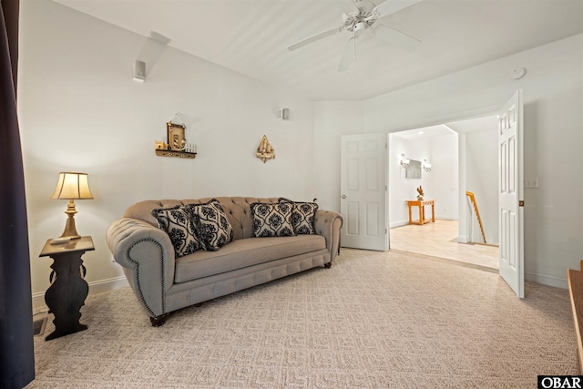 living room featuring a ceiling fan, light colored carpet, and baseboards