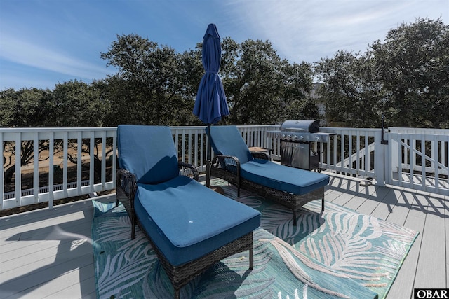 wooden deck with an outdoor living space and area for grilling